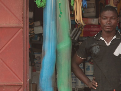 A Ghanaian entrepreneur standing in front of his shop
