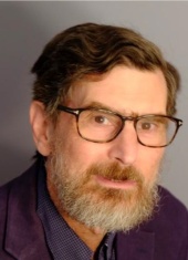 Man with brown hair, dark rimmed glasses, and a brown and gray beard