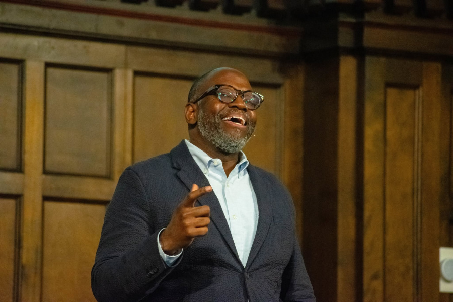 Anthony Bradley speaks positively on a dark wood stage